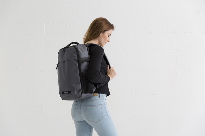 Woman wearing jeans and sweater with a backpack