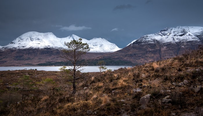 Snow-capped Torridon hills in Scotland with trees