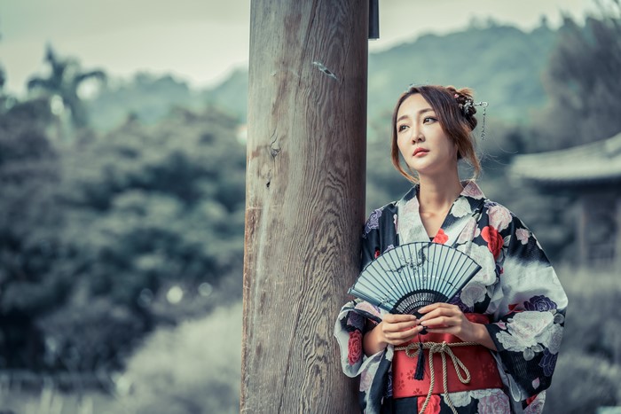 Asian woman in kimono holding a fan
