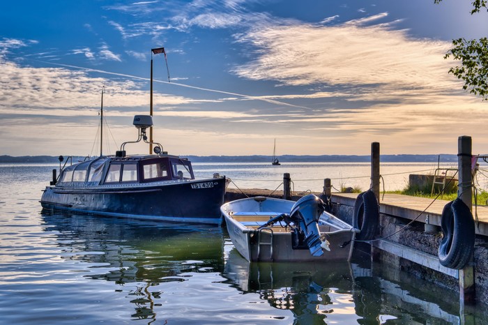 Boats docked at a pier during sunset