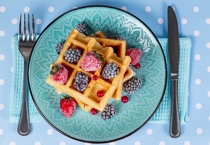 Waffles with Berries on a Plate with Fork and Knife