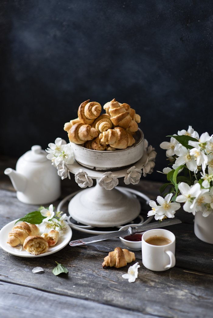 Coffee and croissants on a wooden table with flowers