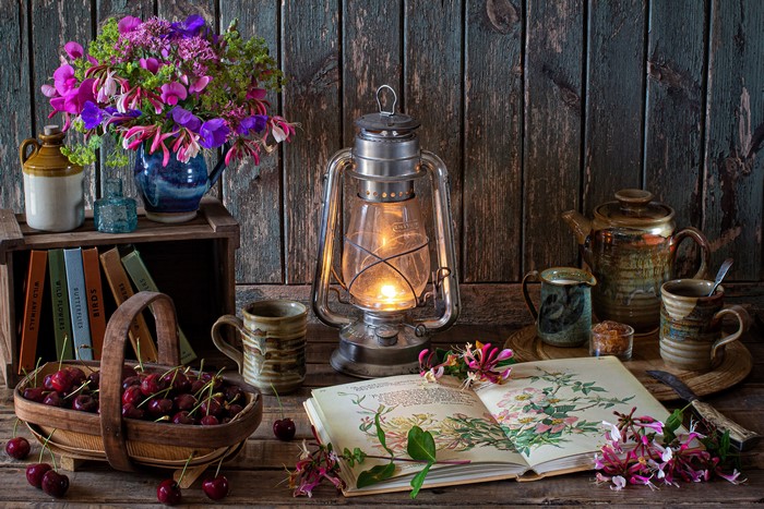 Still-life with bouquet, kerosene lamp, cherries, books, and pottery