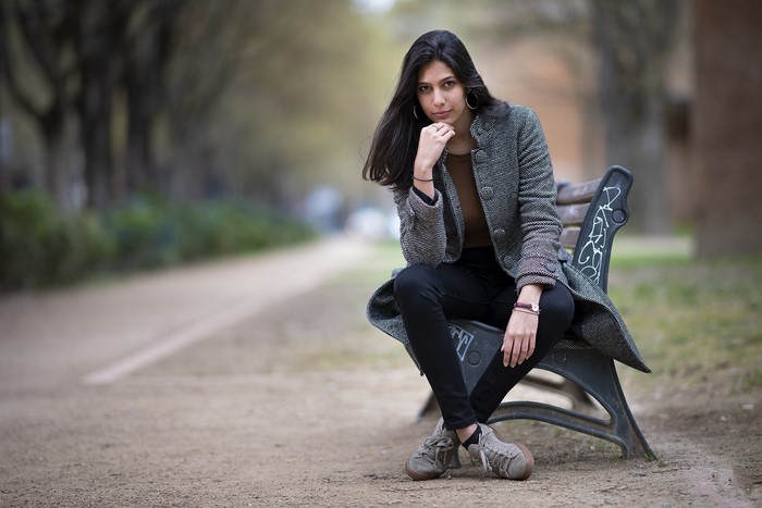 Brunette girl sitting on a bench in a park