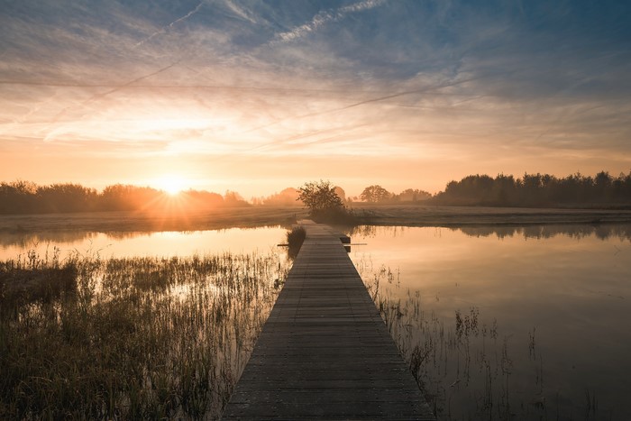 4K Sunrise over canal with wooden pier in Netherlands