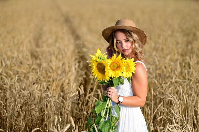 Woman in Hat with Sunflowers in Field