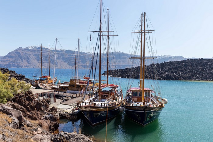Sailing ships docked in a bay in Santorini, Greece