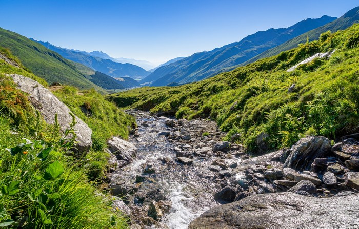 Mountain valley with a stream and green hills