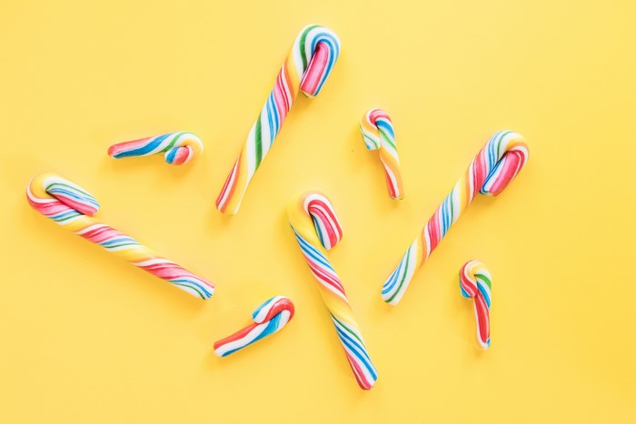 Colorful candy canes on a yellow background