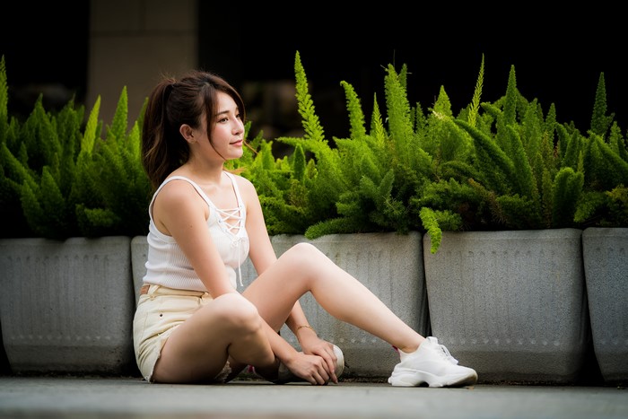 Asian woman sitting in shorts and singlet