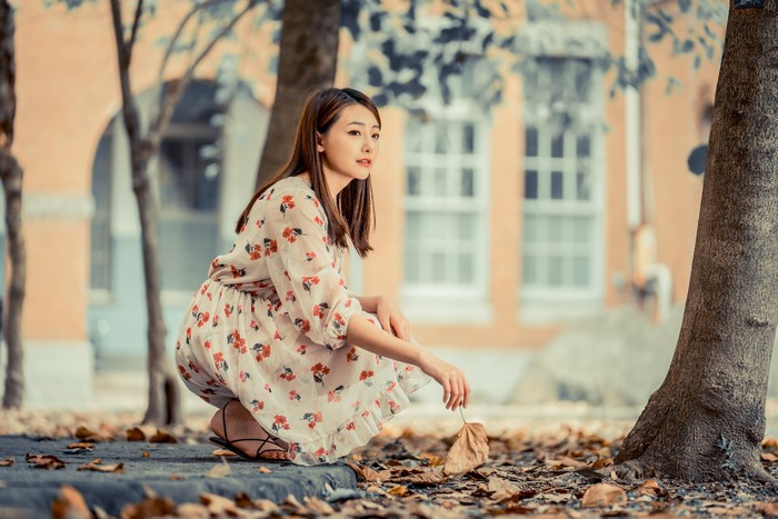Asian woman in floral dress in autumn