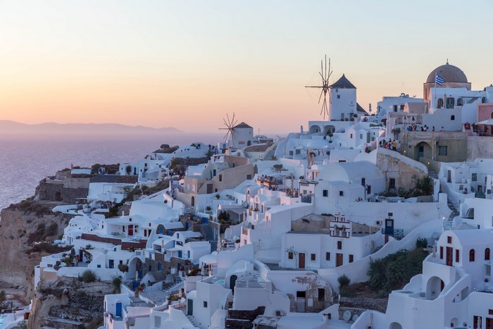 White houses and windmills in Oia, Santorini at sunset