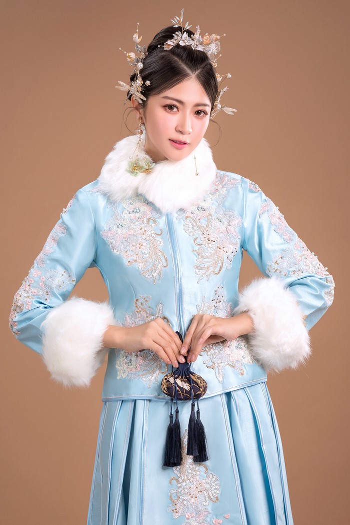 Woman in traditional blue embroidered coat with fur trim