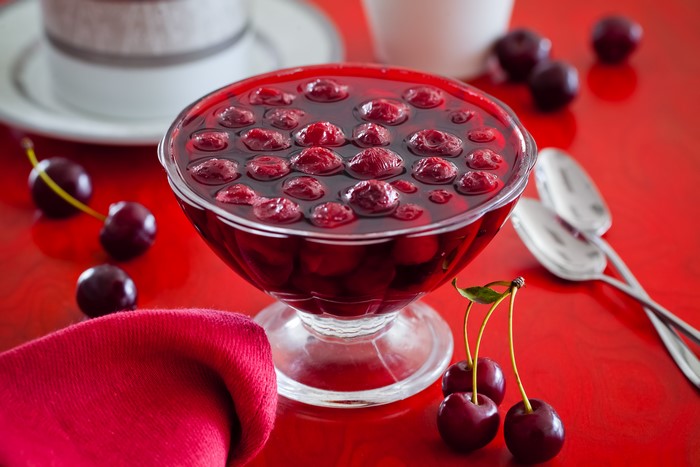 Cherry Jam in a Bowl with Cherries and Spoons