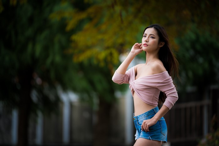 Asian woman in off-shoulder top and shorts posing