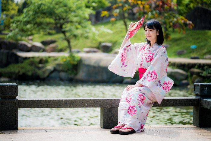 Woman in Kimono Holding Hand Fan in Garden