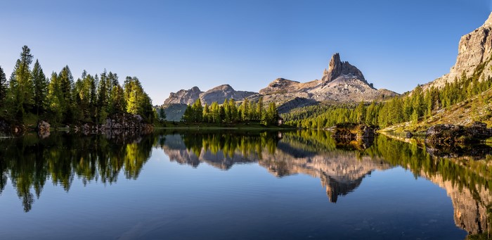 Lake reflection of mountains and trees in the Dolomites, Italy