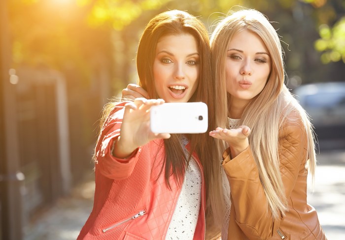 Two girls taking a selfie with a smartphone