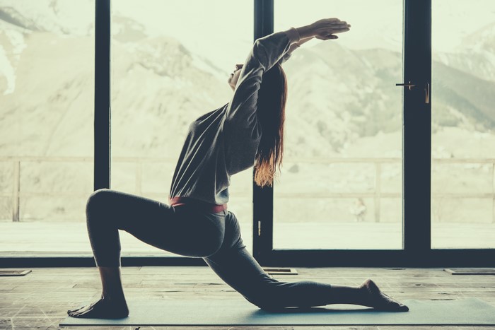 Woman performing a yoga pose with arms raised