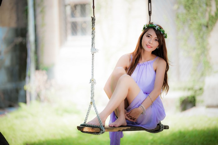 Asian woman with wreath on swing