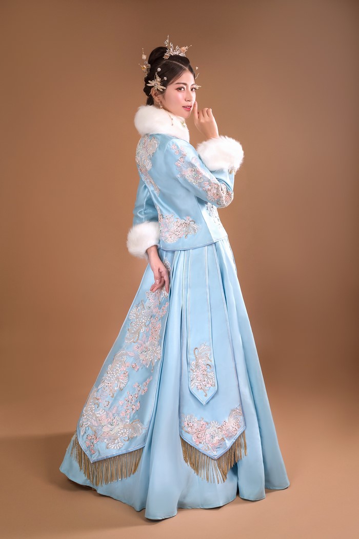 Woman in blue traditional Chinese dress with fur trim