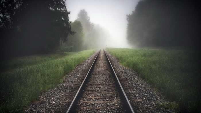 Railroad tracks disappearing into fog