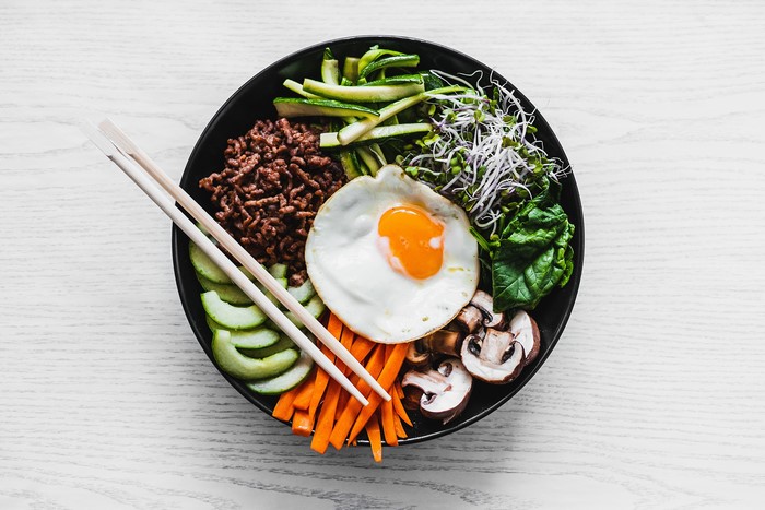 Bibimbap with fried egg and chopsticks