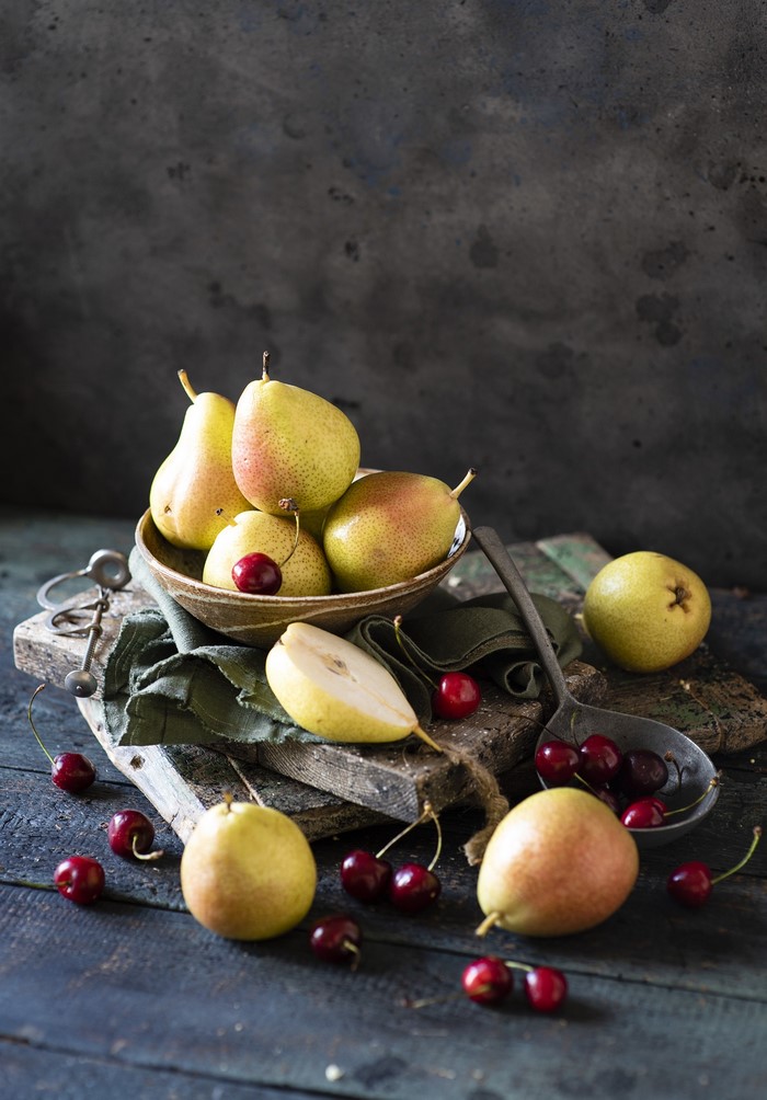 Pears and cherries on a rustic wooden table