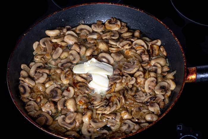 Mushrooms frying in a pan with butter