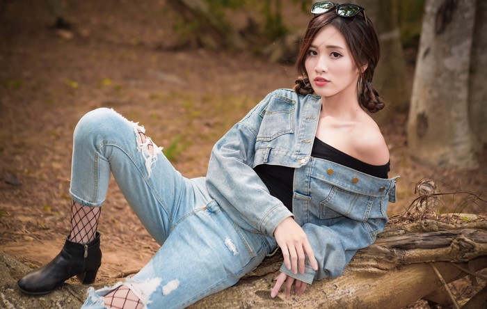 Asian woman in denim jacket and ripped jeans