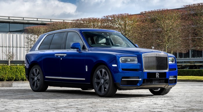 Blue Rolls-Royce Cullinan parked outside a modern building