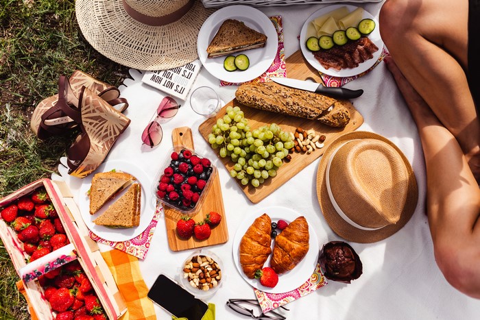 Picnic with bread, berries, croissants, and sandwiches
