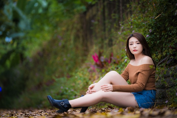 Asian woman with brown hair sitting outdoors
