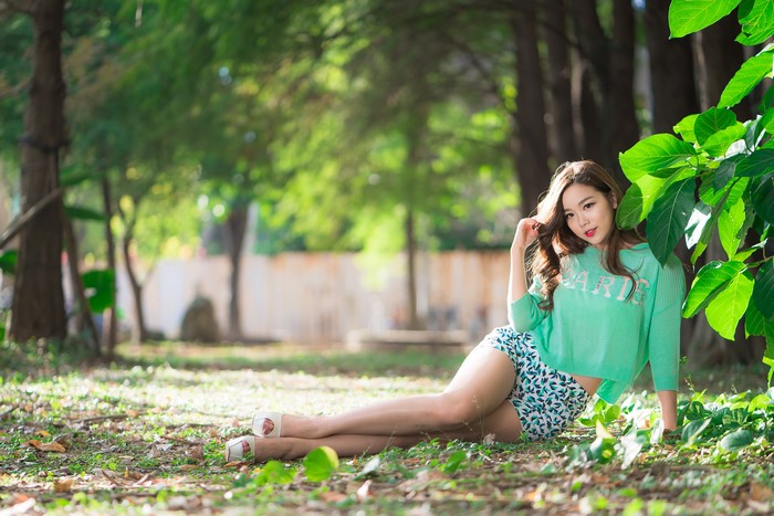 Asian woman in shorts and sweater in park