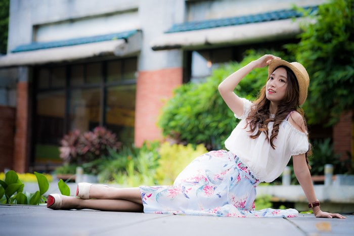 Asian woman with hat and floral skirt