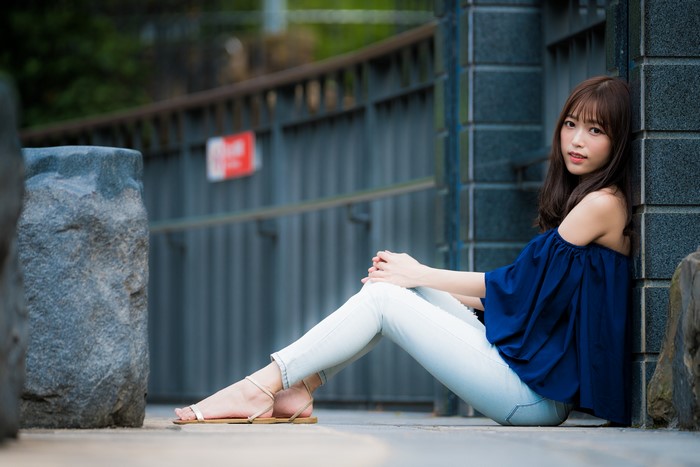 Asian woman with brown hair sitting outdoors