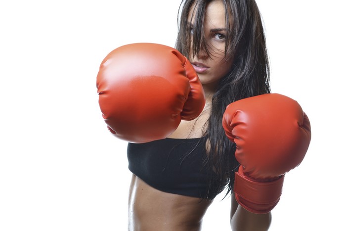 Woman in boxing gloves on white background