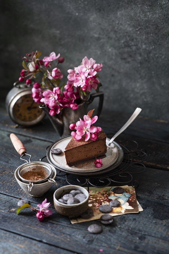Chocolate cake with pink flowers and vintage clock