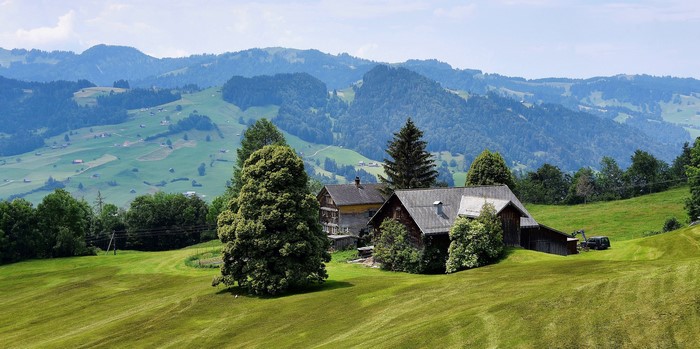 Houses in Toggenburg, Switzerland with rolling hills and trees