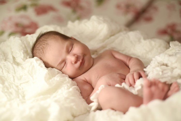 Newborn baby sleeping on white blanket