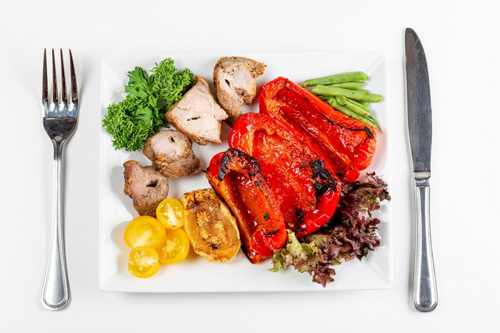 Meat and vegetables with fork and knife