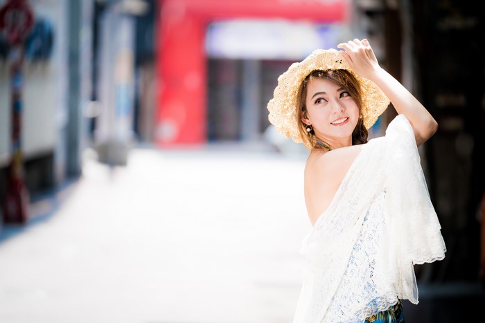 Asian woman with brown hair wearing a straw hat
