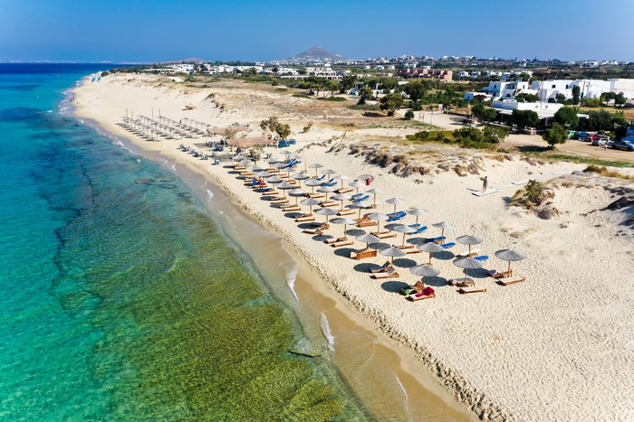 Beach with umbrellas and lounge chairs in Naxos, Greece