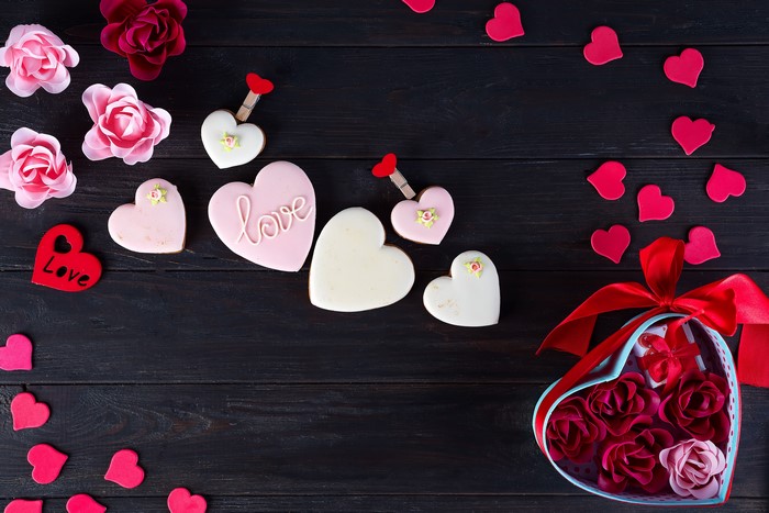 Valentine's Day heart cookies and roses on wood