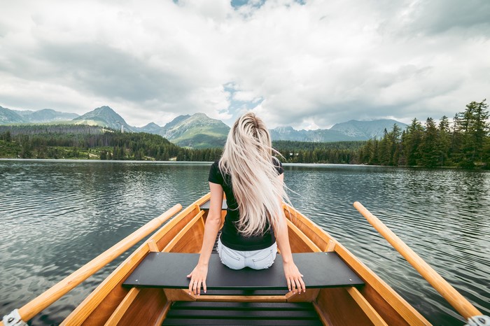 Woman in a boat on a lake with mountains