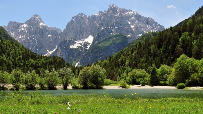 Mountain lake with forest and snow-capped peaks