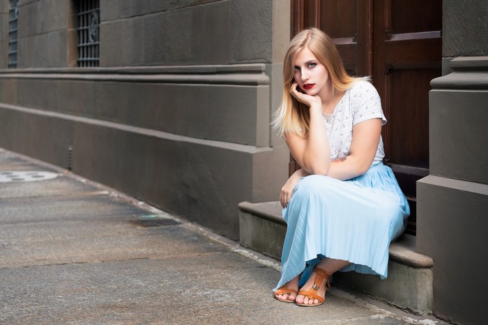 Giulia sitting on steps with hands on chin