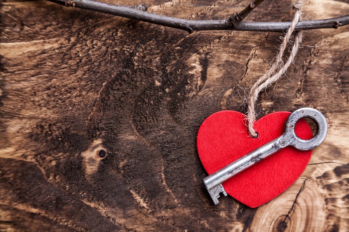 Red Heart with Key on Wooden Background