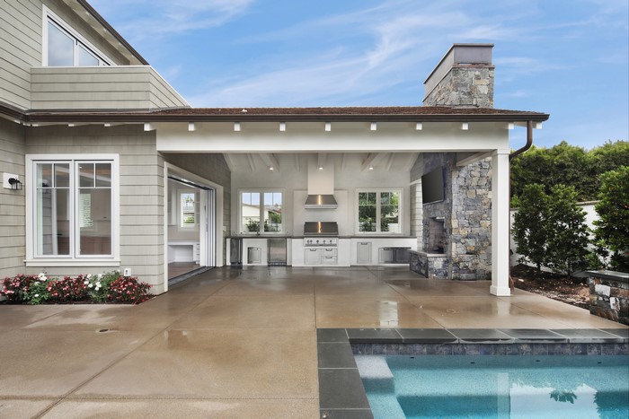 Outdoor kitchen and living area with pool in Newport Beach, California