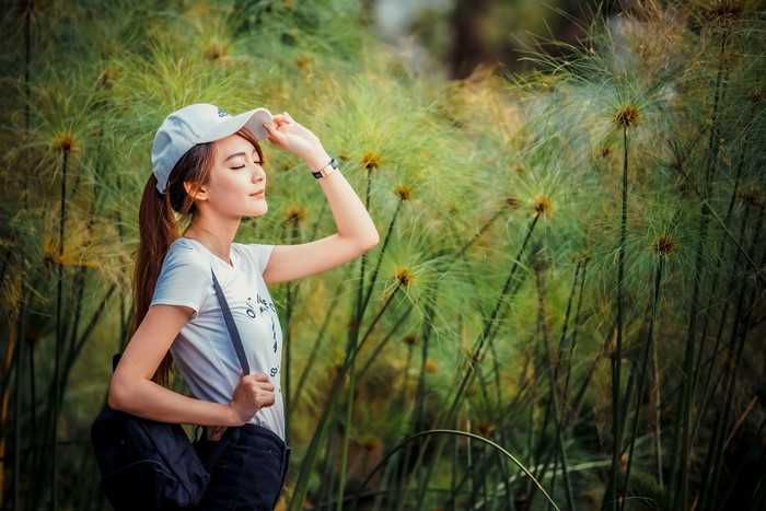 Asian woman wearing a baseball cap and t-shirt